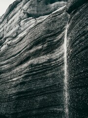 Greyscale of a rock formation with a small stream trickling down, Katla region of Iceland