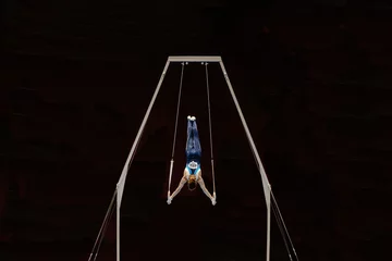 Foto op Plexiglas male gymnast performing on ring frame competition artistic gymnastics, black background © sports photos