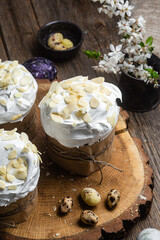 Easter cake with meringue and almond petals on a wooden background