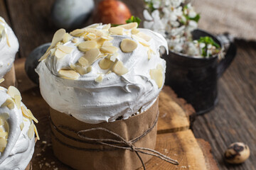 Easter cake with meringue and almond petals on a wooden background