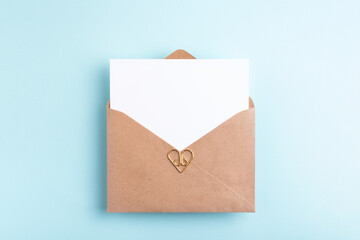 White paper card in kraft envelope. Top view, place for text.