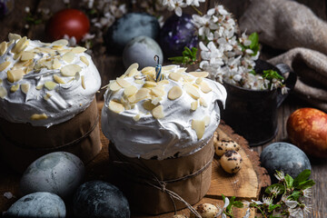 Easter cake with meringue and almond petals on a wooden background