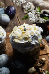 Easter cake with meringue and almond petals on a wooden background