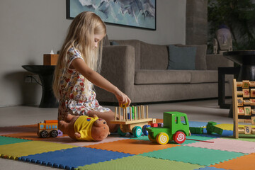 Adorable little girl playing with wooden toys at home	