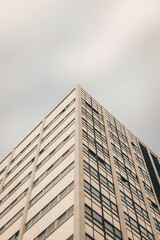 Fotografía de arquitectura, esquina de edificio con tonos claros y día nubloso.