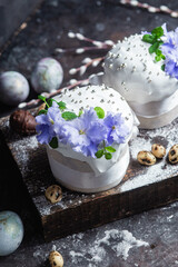 Easter cake with meringue and violets on a dark background