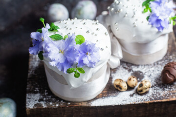 Easter cake with meringue and violets on a dark background