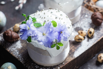 Easter cake with meringue and violets on a dark background