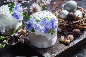 Obraz na płótnie Canvas Easter cake with meringue and violets on a dark background