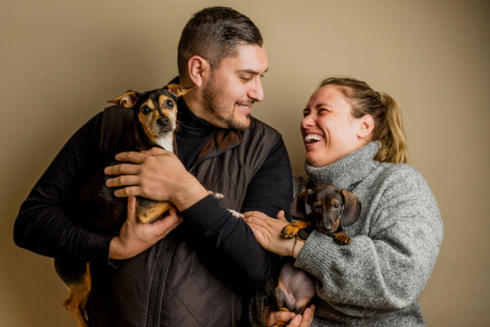 happy couple posing with his pets dogs , smiling and enjoying