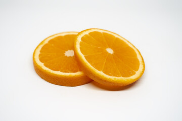 Fototapeta na wymiar Two slices of ​​orange on white isolated studio background side view