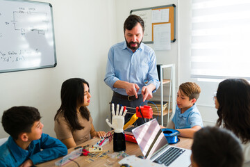 Teen boys and girls making robot prototypes at school