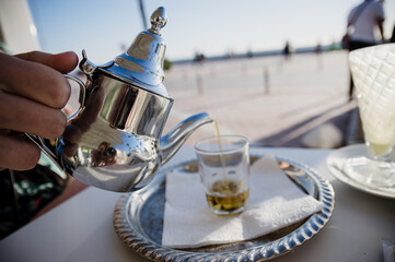 Traditional Moroccan tea pot with a cup outside ready to drink