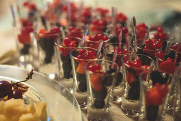 Catering table, beautifully decorated banquet with variety of with different food snacks appetizers on corporate birthday party event or wedding celebration, canape, salad, delicatessen setting