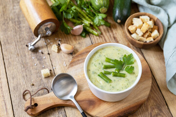 Vegan soup puree of green vegetables. Bowl of green bean and zucchini cream soup on a rustic table. Healthy diet low carb. Copy space.