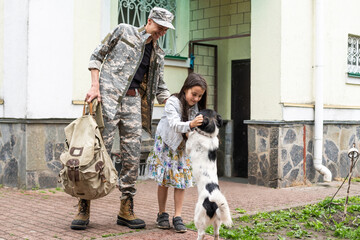 Little child is very happy her father came back from army. Little kid is hugging her father