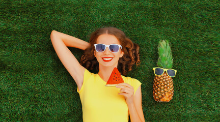 Summer portrait of happy smiling young relaxing woman with fruits, pineapple in sunglasses lying on...