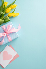 Mother's day celebration concept. Top view of trendy gift boxes postcard and yellow tulips on pastel blue background with space for text or greeting message