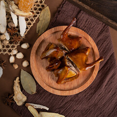 Pigeon meat marinated with spices, Chinese specialty food, shot in the kitchen, dark background, with various spices