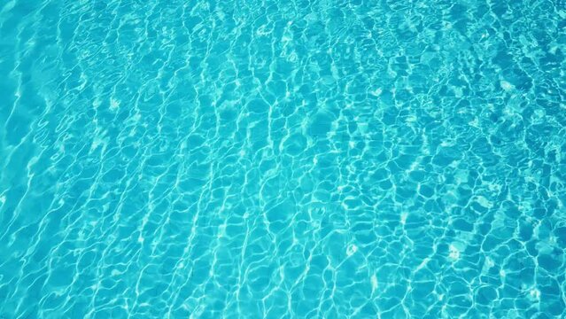 Top down view seabed texture, sea floor beach sand ripple of water waves reflection. Blue turquoise sandy bottom surface summer background slow motion. Underwater seafloor close-up