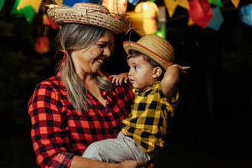 Mother and her baby son celebrating the Brazilian Festa Junina. Portrait of a woman and her son...