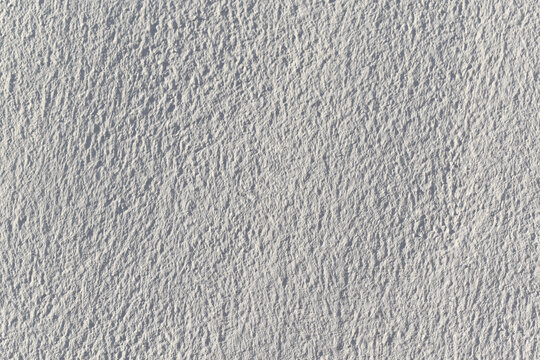 White paint stucco wall texture background.  White wall texture in the sun. 