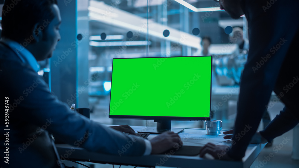 Aufkleber Two Developers Working on Computer with Green Screen Mock Up Display. Scientific Lab, Engineering Research Center with Specialists Working on Turbine Engine Development in the Background.