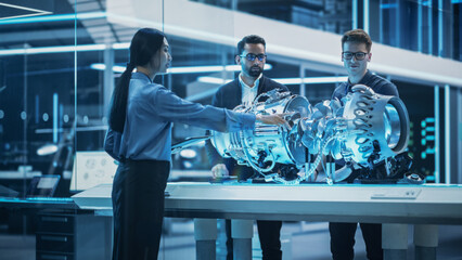 Software Developer, Project Manager and Machinery Operators Collaborate on a Prototype Turbine Engine, Standing with Laptop Computer in Scientific Technology Lab. Team Developing a New Electric Motor