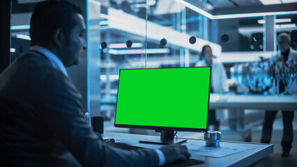 Software Developer Working on Computer with Green Screen Mock Up Display. Scientific Lab,...