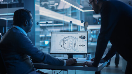 Two Industrial Engineers Discussing Work Projects, Talk and Use Desktop Computer in Turbine...