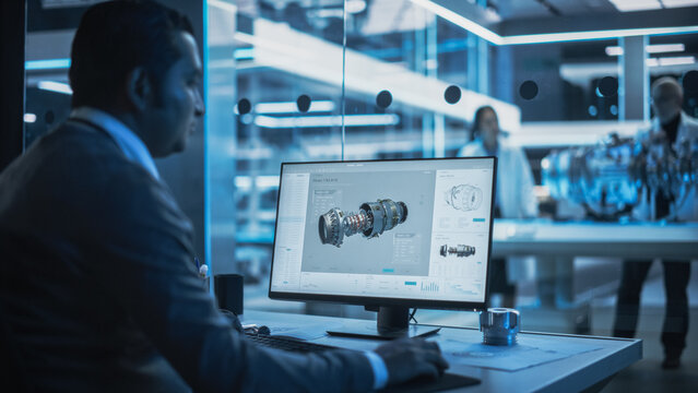 Industrial Designer Working on CAD Software on Desktop Computer in Turbine Engine Startup Facility. Specialists and Professionals Researching and Developing High Tech Engine Technology.