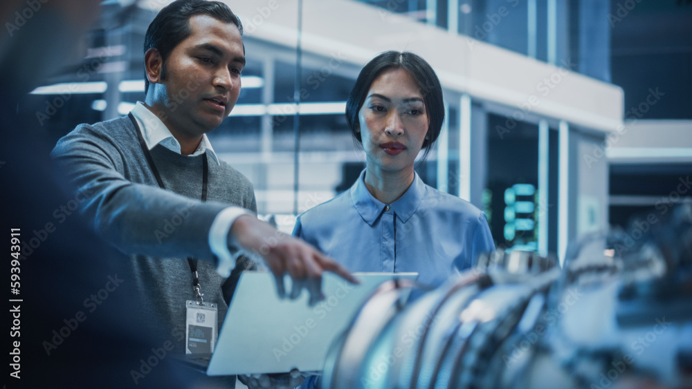 Poster two multiethnic employees work in modern innovative research facility with a futuristic jet engine. 