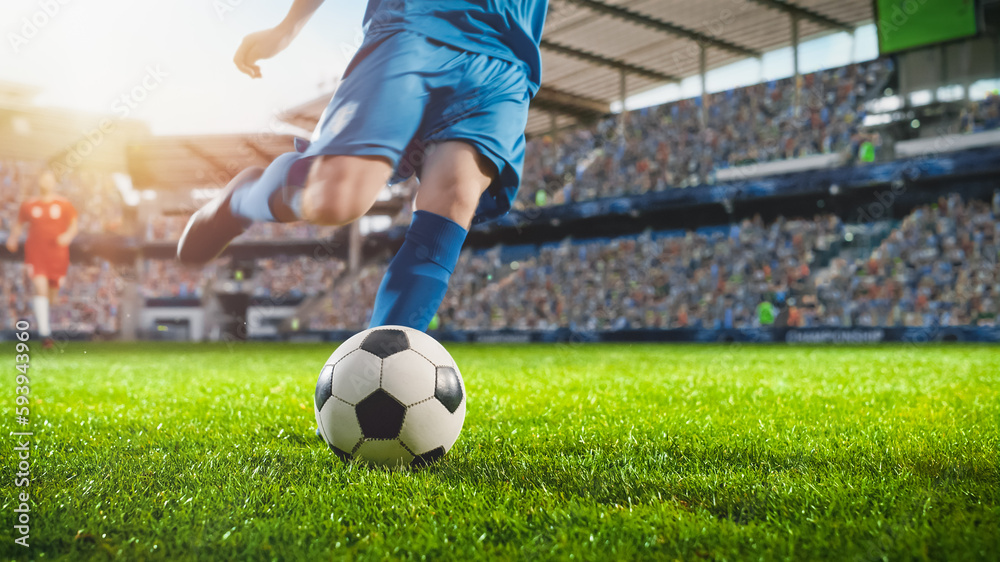 Wall mural Football World Championship: Soccer Player Runs to Kick the Ball. Ball on the Grass Field of Arena, Full Stadium of Crowd Cheers. International Tournament Concept. Cinematic Shot Captures Victory.