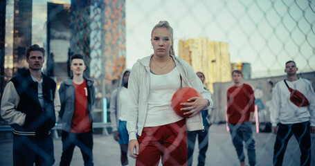 Group of Diverse Multiethnic Young Adult People Standing on Rooftop, Looking and Posing for Camera in an Urban City Environment. Footage Focusing on a Athletic Female with Red Soccer Ball