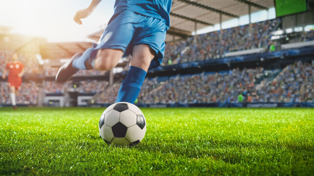 Football World Championship: Soccer Player Runs to Kick the Ball. Ball on the Grass Field of Arena, Full Stadium of Crowd Cheers. International Tournament Concept. Cinematic Shot Captures Victory.