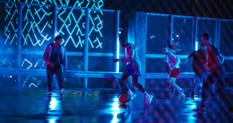 Young Black Man Playing Soccer with Diverse Friends. Multiethnic Stylish Group Enjoying a Game of Football at a Neon Urban Spot on Rooftop with Skyscrapers at Night. Slow Motion Shot