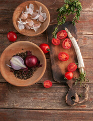 cocktail  tomatoes on a wooden board with various vegetables and garlic and black pepper