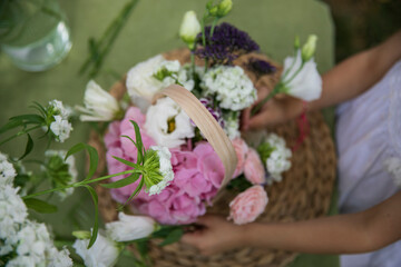 Obraz na płótnie Canvas Top view of a workshop florist, making bouquets and flower arrangements. A woman collecting a bouquet. 