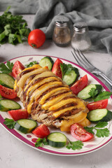 Pork baked with onion and cheese served with vegetables on a plate