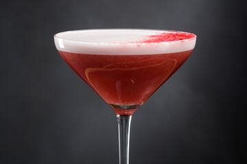 Margarita cocktail drink on a dark gray background. Alcoholic refreshing cocktail with strawberry pulp in a glass. Shallow depth of field