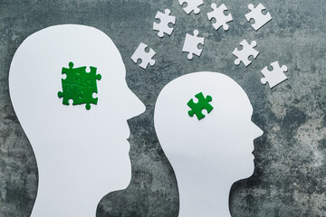 Eco-anxiety affecting mental health. Paper cuting two heads with green puzzles in concrete...