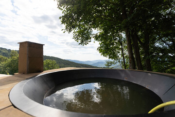 Big vat with hot water and herbs for bathing, spa and relax. mountains