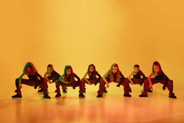 Art, performance. Group of little talented girls, children in sport style clothes dancing hip-hop...