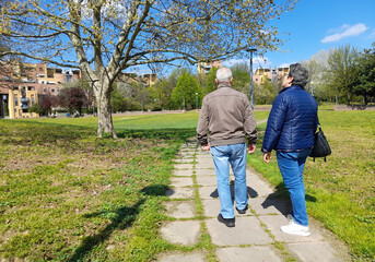Due anziani a passeggio nel parco urbano