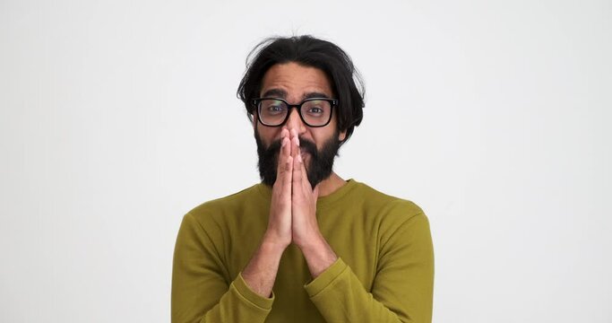 Closeup of excited bearded young man screaming ecstatically and gesturing while standing isolated against white background
