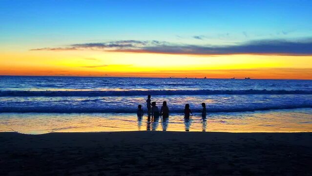 家族とビーチで夕日を見る