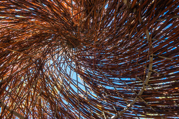 The roof of the hut is made of twigs from the inside. Weaving of twigs and branches.