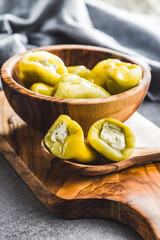 Peppers stuffed with cream cheese on wooden spoon.