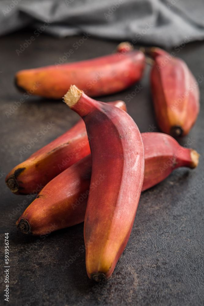 Sticker tasty red bananas on black table.