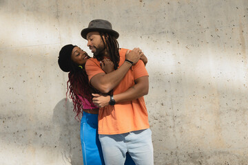 Portrait of African-American couple embracing each other. Smiling happy girlfriend and boyfriend enjoy outside..